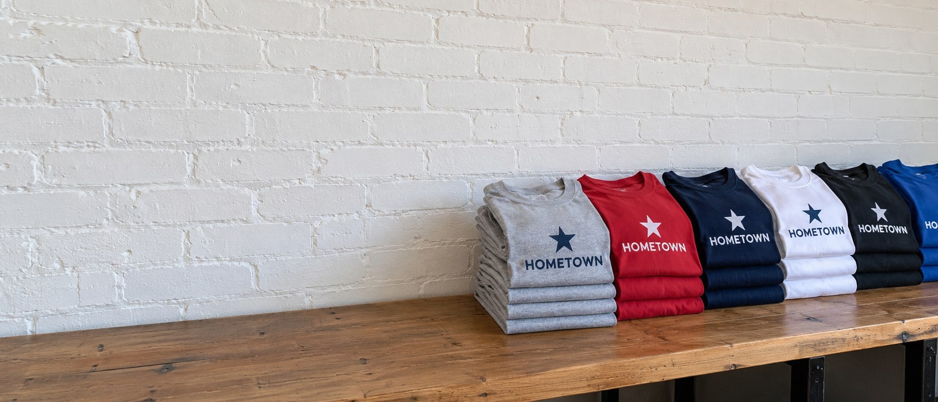 Bulk custom t-shirts folded in neat stacks on a table